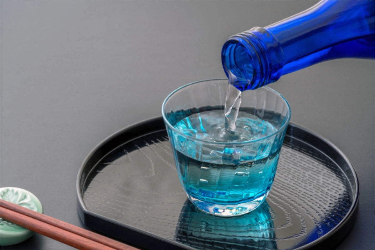 青い瓶からガラスの部位のみに日本酒を注ぐ